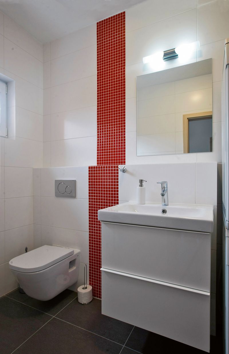 V koupelně v přízemí slouží červená mozaika k optickému oddělení WC.