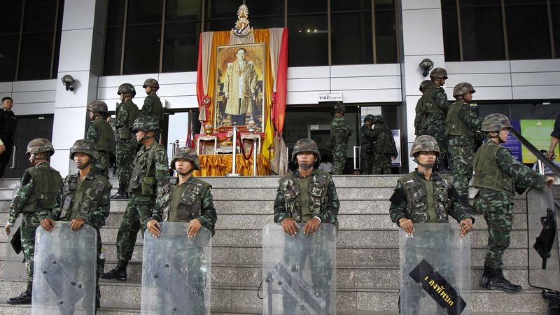 Thajští vojáci před portrétem krále před budovou soudu