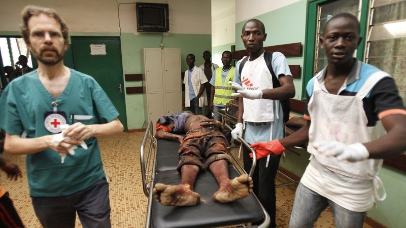 Pracovníci Červeného kříže doprovázejí zraněného civilistu v nemocnici v Bangui 