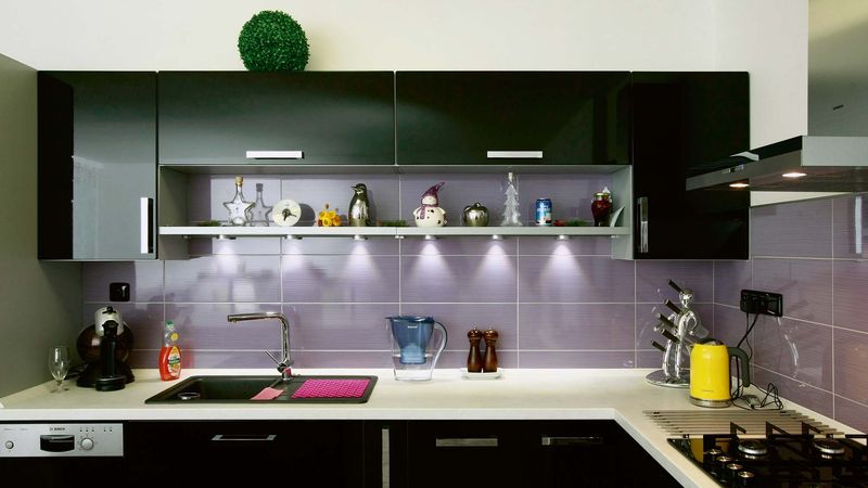 Působivou kombinaci černobílé kuchyňské linky zklidňují fialové obklady.