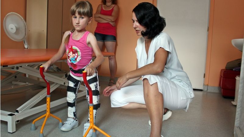 Pod dohledem fyzioterapeutky a své maminky trénuje Veronika chůzi o berlích.