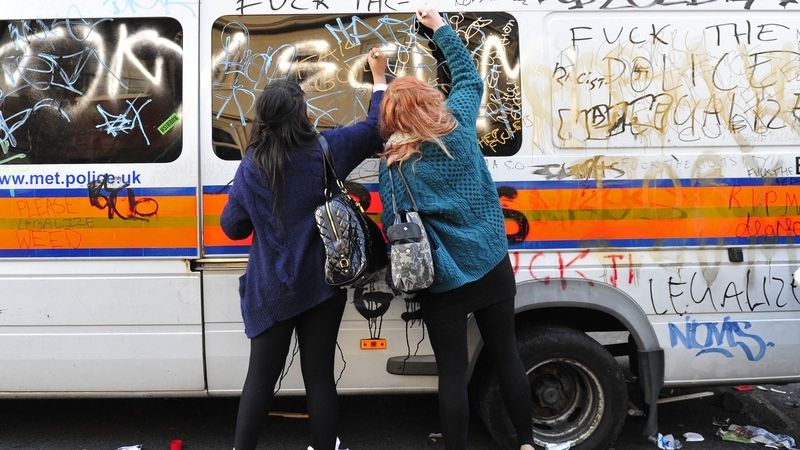 Demonstranti stříkají nápisy na policejní anton