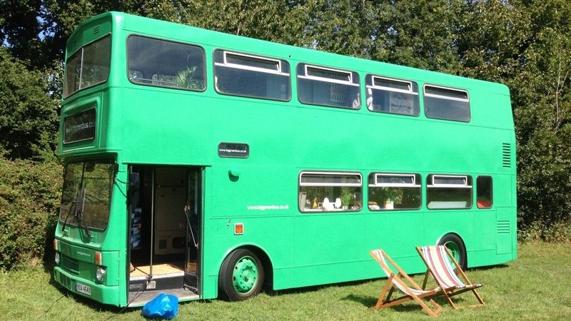 Zelený dvoupatrový autobus slouží jako báječný obytný vůz na kempování.