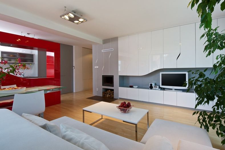 Obývací pokoj spojený s kuchyňským koutem je orientovaný na jihozápad. Díky orientaci i zvolenému lesklému materiálu a bílé barvě působí čistým a světlým dojmem. 