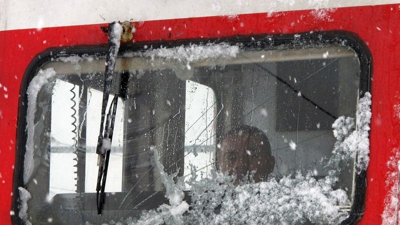 Turecký strojvůdce za zasněženým oknem lokomotivy v Ankaře