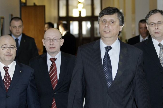 Premiér Jan Fischer přichází se spolupracovníky a ministrem obrany Martinem Bartákem (vlevo) na jednání vlády.