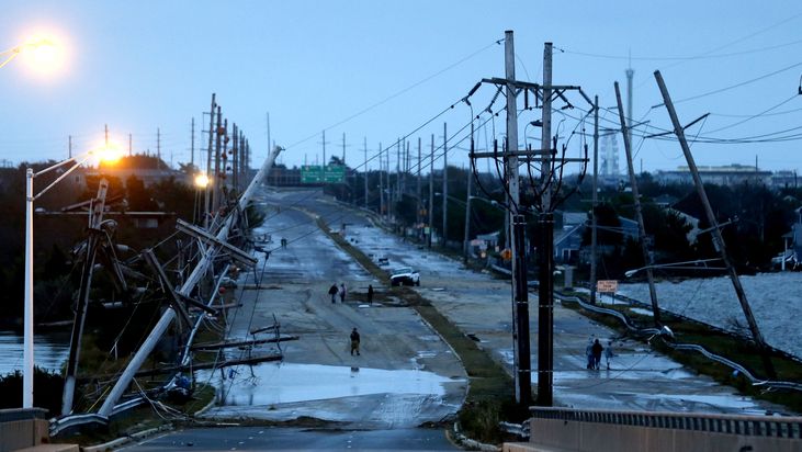 Poničená silnice a sloupy elektrického vedení na ostrově Seaside Heights.