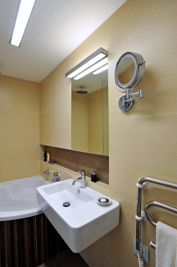 Prostor koupelny je malý, nejen proto barevnost a vzor obkladu byly zvoleny střízlivě. Sanitární keramika je od výrobce Vitra. Kabeláž je uschovaná v kabelovém kanálu, který vede po celé délce stolové desky. Je vyrobený z lamina v dekoru jilmové dřevo.