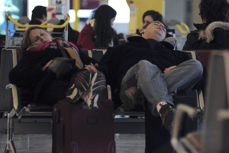 Spící cestující na pařížském letišti Charlese de Gaulla