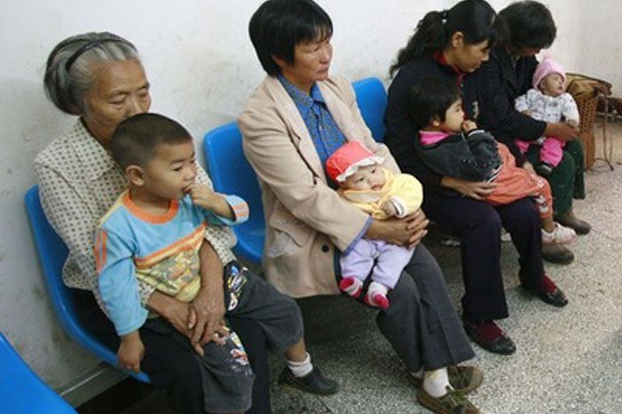 Děti čekají na ošetření po požití sušeného mléka, v němž byly chemikálie. problémy s ledvinami má asi 6500 dětí.