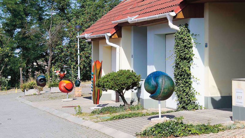 Klidnou ulici v létě ozvláštnily dřevěné plastiky z ateliéru Dušana Tejkala.