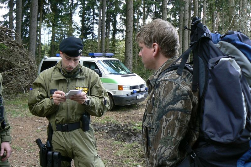 Vojenská policie kontroluje doklady aktivisty, který opouští kótu 718 v Brdech.