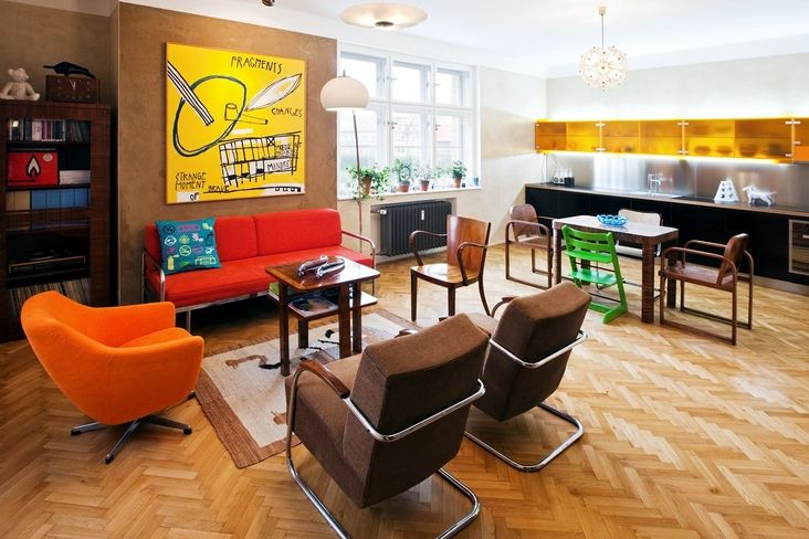 Obývací pokoj propojený s kuchyní představuje vyváženou kombinaci retronábytku s moderní kuchyňskou sestavou z betonářské překližky. Výraznou dekorací je obraz z dílny rodinného přítele a spolupracovníka Andrého. 