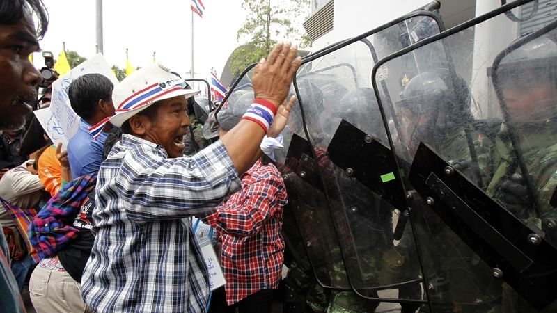 Thajský demonstrant před kordonem bezpečnostních sil 