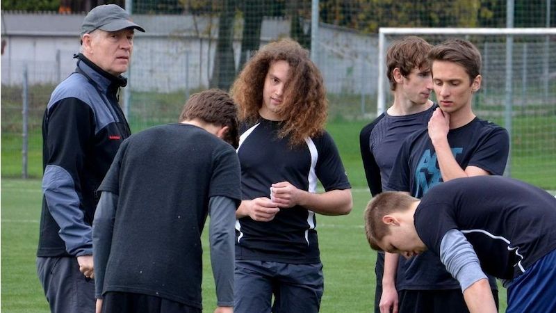 L. Vrátný (vlevo) předává své postřehy školnímu fotbalovému družstvu.