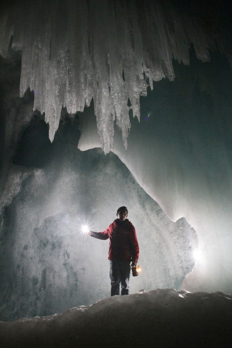 Oči turistů si v největší ledové jeskyni světa musejí přivyknout na tmu a šero.