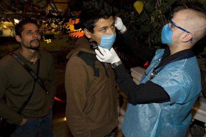 Muži je měřena teplota před vstupem do baru v Mexico City. Virus prasečí chřipky zde zabil několik desítek lidí.
