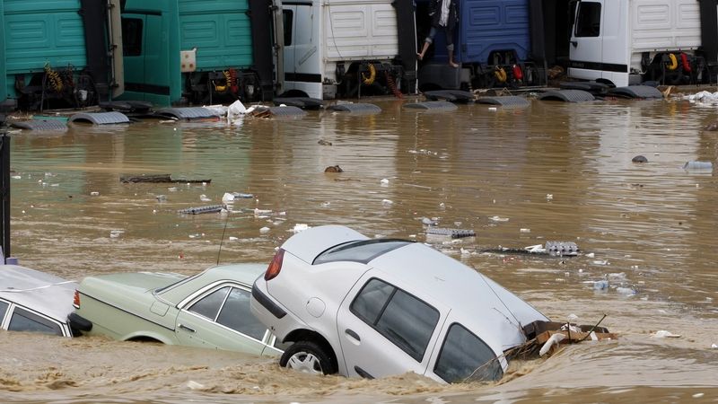 Turek u zaplavených aut čeká na záchranu. 