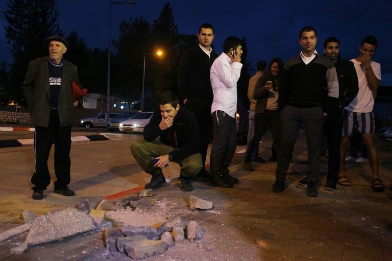 Izraelci si prohlížejí škodu způsobenou jednou z dopadnuvších palestinských raket.
