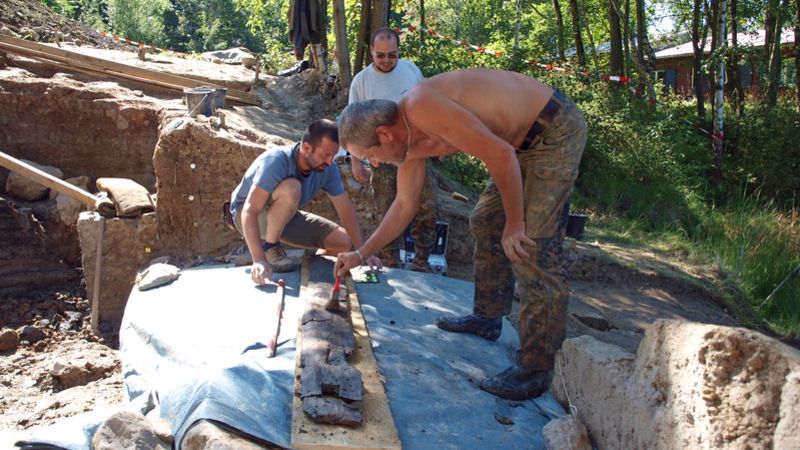 Archeologové ošetřují jeden z vyzvednutých dubových trámů cisterny na Vladaři