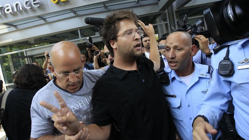 Izraelští policisté odvádějí propalestinského aktivistu, který se snažil vzbudit rozruch na mezinárodním Ben-Gurionově letišti v Tel Avivu.