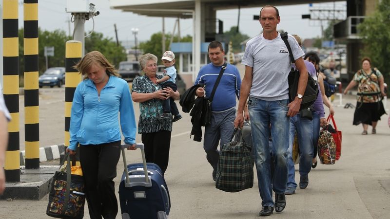 Lidé na východě Ukrajiny překračují hraniční přechod do Ruska.