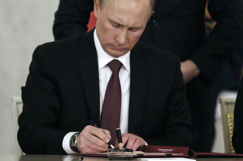 Ruský prezident Vladimir Putin podepisuje návrh smlouvy o připojení Krymu k Rusku