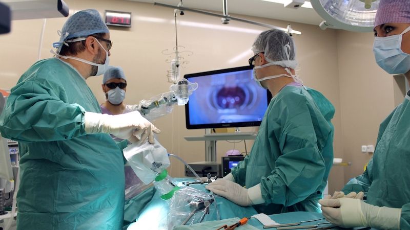Tým neurochirurgů s 3D brýlemi, které umožňují vidět operovanou část těla pacienta na obrazovce v trojrozměrném zobrazení.