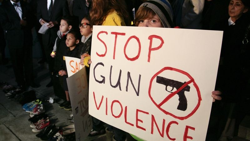 Devítiletá dívka s transparentem vyzývajícím k zastavení násilí na demonstraci v Los Angeles.
