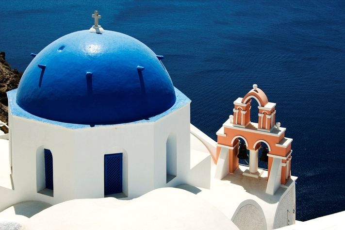 Bílé domky s modrými okenicemi a střechami – to jsou poznávací znamení ostrova Santorini.
