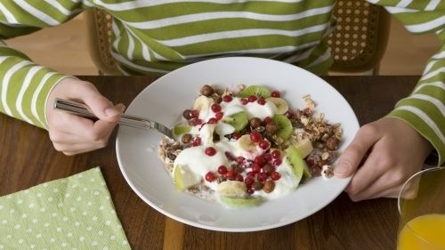 Vydatná snídaně složená z jogurtu, müsli a ovoce, navíc sněděná neze spěchu, je ideálním startem do sychravého dne.