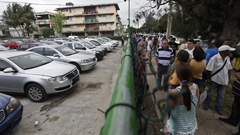 Kubánci před parkovištěm se zahraničními vozy
