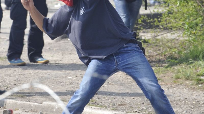 Demonstrant háže kamínek na policisty