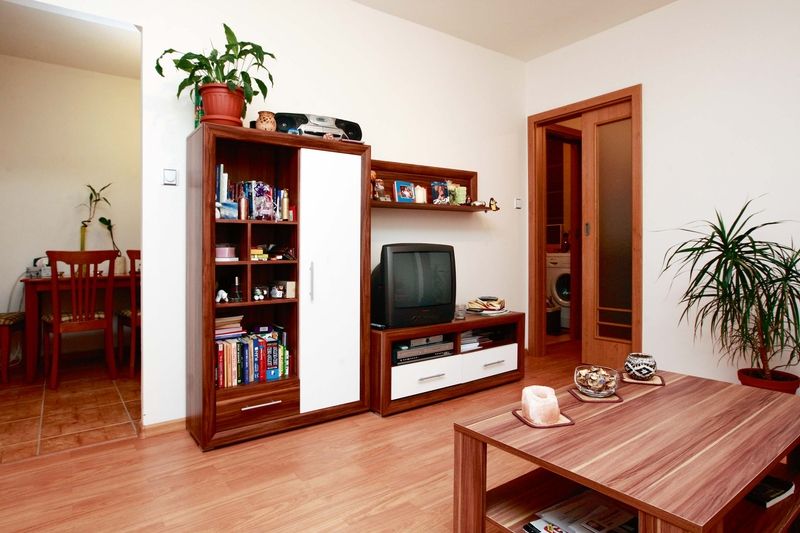 Výmalba v bílé barvě dobře kontrastuje s podlahou a nábytkem v bílodřevěném dezénu. 