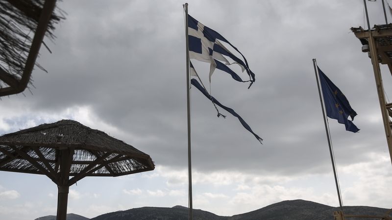 Potrhané vlajky Řecka a EU vlají ve vesnici Anavissos jihozápadně od Atén.
