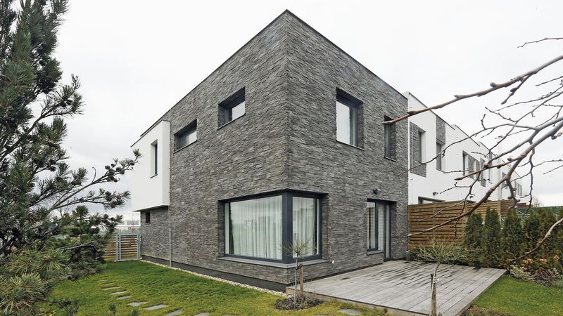 Kombinace betonového obkladu s klasickou fasádou je zajímavým architektonickým prvkem rodinného domu.