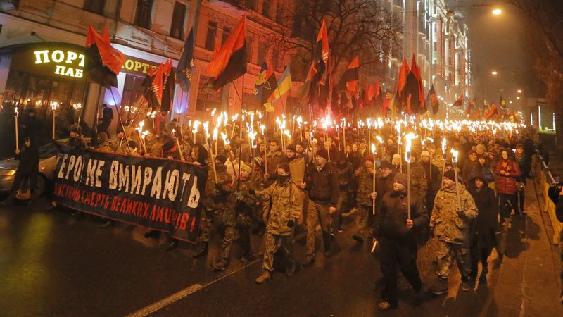 Nacionalisté pochodují centrem Kyjeva, aby uctili památku Stepana Bandery. Jejich transparent hlásá, že hrdinové nikdy neumírají.