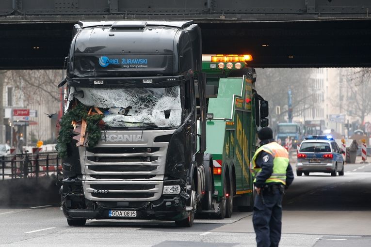 Německý policista sleduje odtahování kamiónu použitého k útoku.
