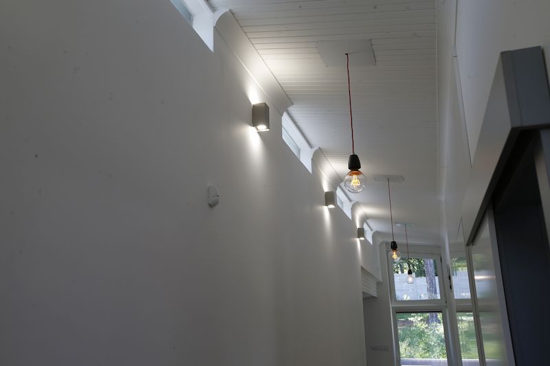 Nenápadný pás oken u stropu zajišťuje dostatek světla v chodbě i v noci.