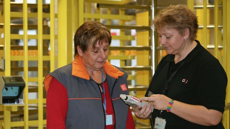 Marika Kohoutková (vpravo) z ostrahy elektrárny vyhodnocuje výsledek testu u jedné zaměstnankyně vstupující do areálu. Ten dopadl negativně, stejně jako drtivá většina ostatních.