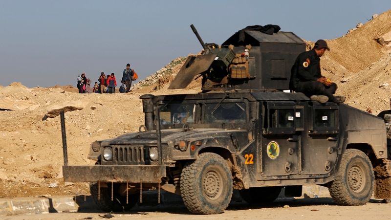 Iráčané z Mosulu prchají kolem humvee irácké protiteroristické jednotky 
