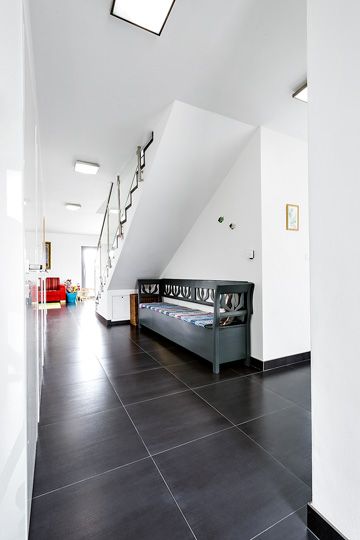 Bílá barva na stěnách umocňuje prosvětlení obytného prostoru a dává vyniknout nábytkovým solitérům, jako je lavice po babičce.