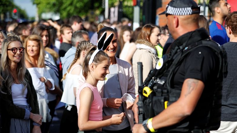 Ozbrojený policista dohlíží na příchod návštěvníků na koncert v Manchesteru.