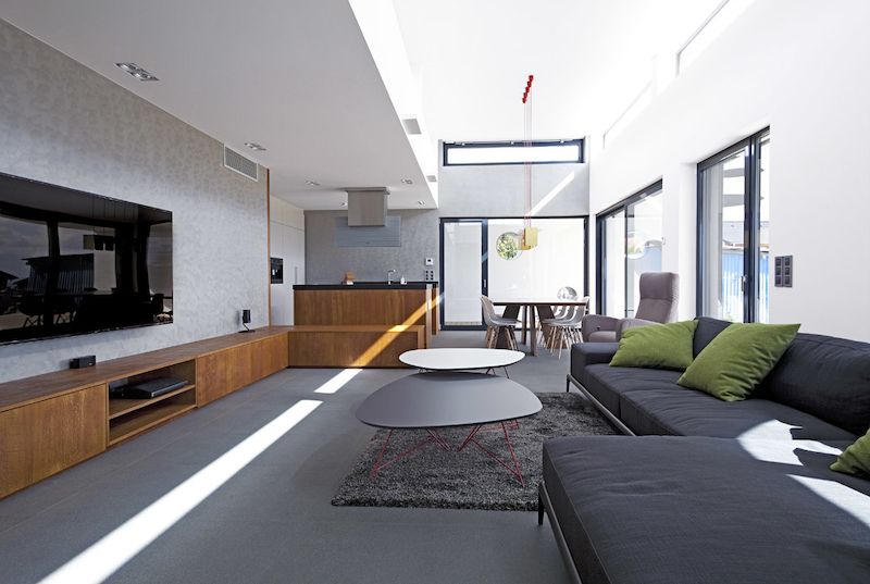 Obývací prostor s kuchyní a jídelnou vnořený do vnějšího rámu získal více světla a prostoru k nadechnutí díky zvýšenému stropu s pásem horizontálních oken.