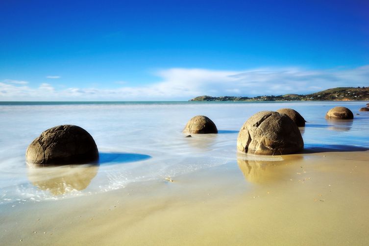 Pravidelné kulaté balvany vypadají na pláži Koekohe poblíž městečka Moeraki jako z jiného světa.
