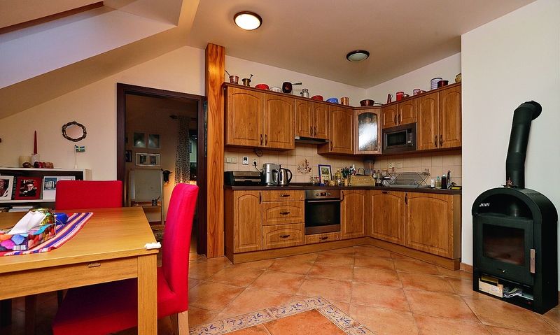 Obývací kout v části podkroví, kde je i kuchyň, je útulný.