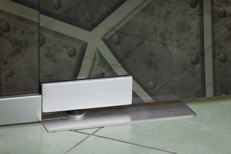 Detail dveřního samozavírače. Pro něj je třeba v podlaze nechat potřebný volný prostor, který lze dobře vyhradit například pomocí kostky polystyrenu.