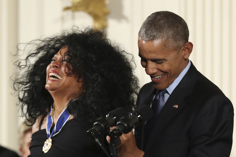 Zpěvačka Diana Rossová se směje, když jí prezident Barack Obama předává medaili. 