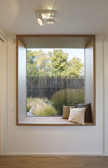 Okno slouží zároveň jako lavice s výhledem do zahrady. Aby vynikl jeho specifický účel, je celé obloženo dřevem a dekoracemi.