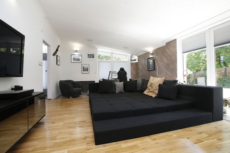 Dominantním prvkem obývacího pokoje je velká čtvercová sedačka.